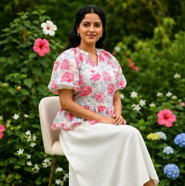 Woman in floral top sitting outdoors